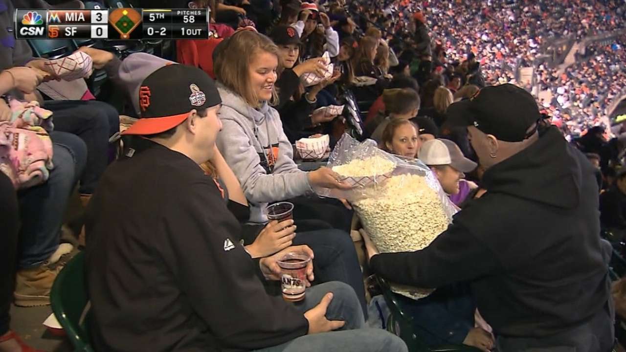 Giants fan shares big bag of popcorn in the stands