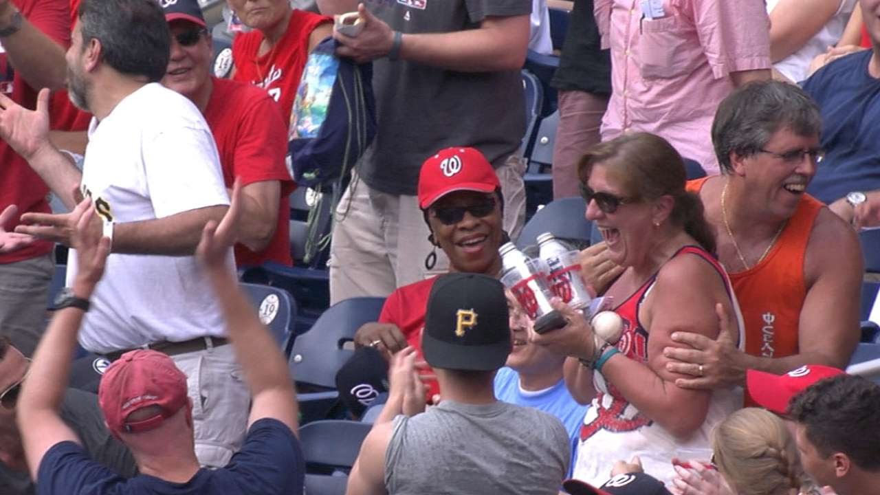 Fan catches a foul ball with two beers in her hands