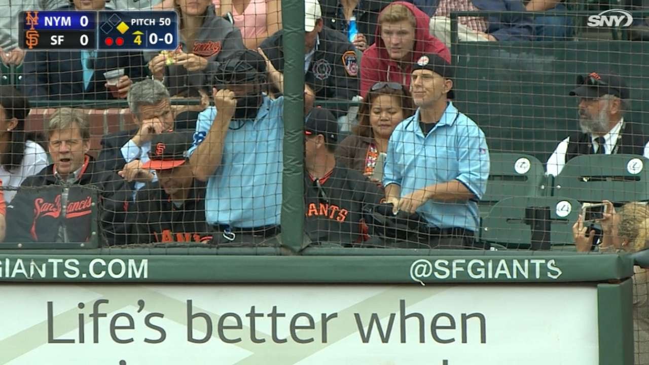 A pair of fans dressed as umpires call the Mets-Giants game from the stands