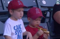 Kid struggles to eat hot dog at baseball game