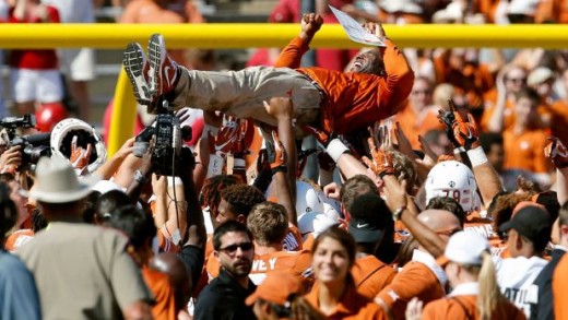 Texas Longhorns players crowd surf head coach Charlie Strong