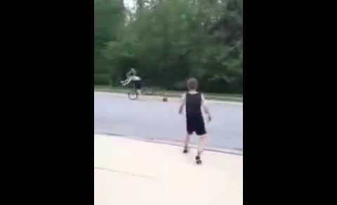 Kid throws basketball at young lady riding a bicycle