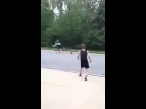 Kid throws basketball at young lady riding a bicycle