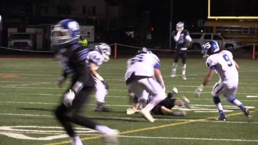 High school football referee trucks receiver forcing a fumble