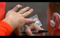 Johnny Manziel signs a $100 dollar bill for a fan