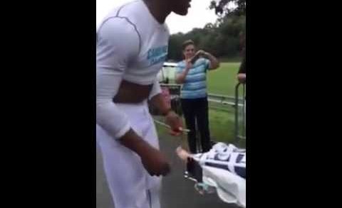 Cam Newton signs his cleats for fan in a wheelchair (Throwback)