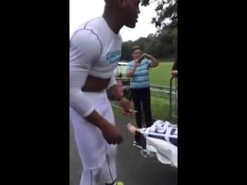 Cam Newton signs his cleats for fan in a wheelchair (Throwback)