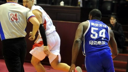 Former NBA player Jason Maxiell chases down a Chinese player to fight him