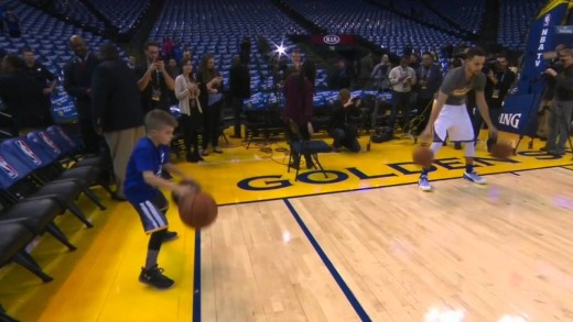 Steph Curry does his pre-game dribbling ritual with a young fan