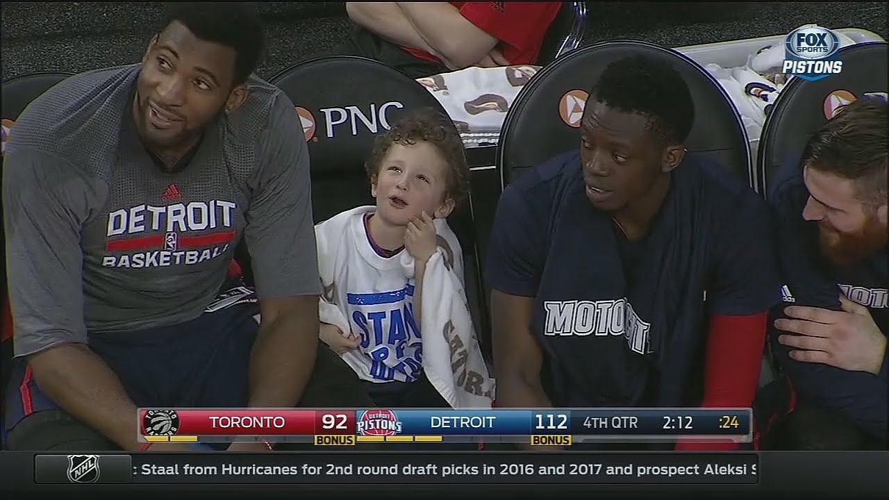 Andre Drummond brings a young fan down to chill on the Pistons bench