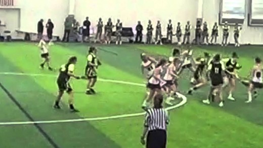 Female lacrosse player drills player 3 times in the face with stick