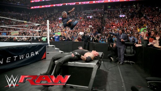 Shane McMahon elbow drops The Undertaker through table