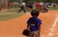 Little leaguer sadly watches fight breakout on the diamond