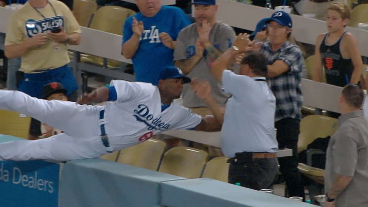 Yasiel Puig falls into the stands chasing a foul ball