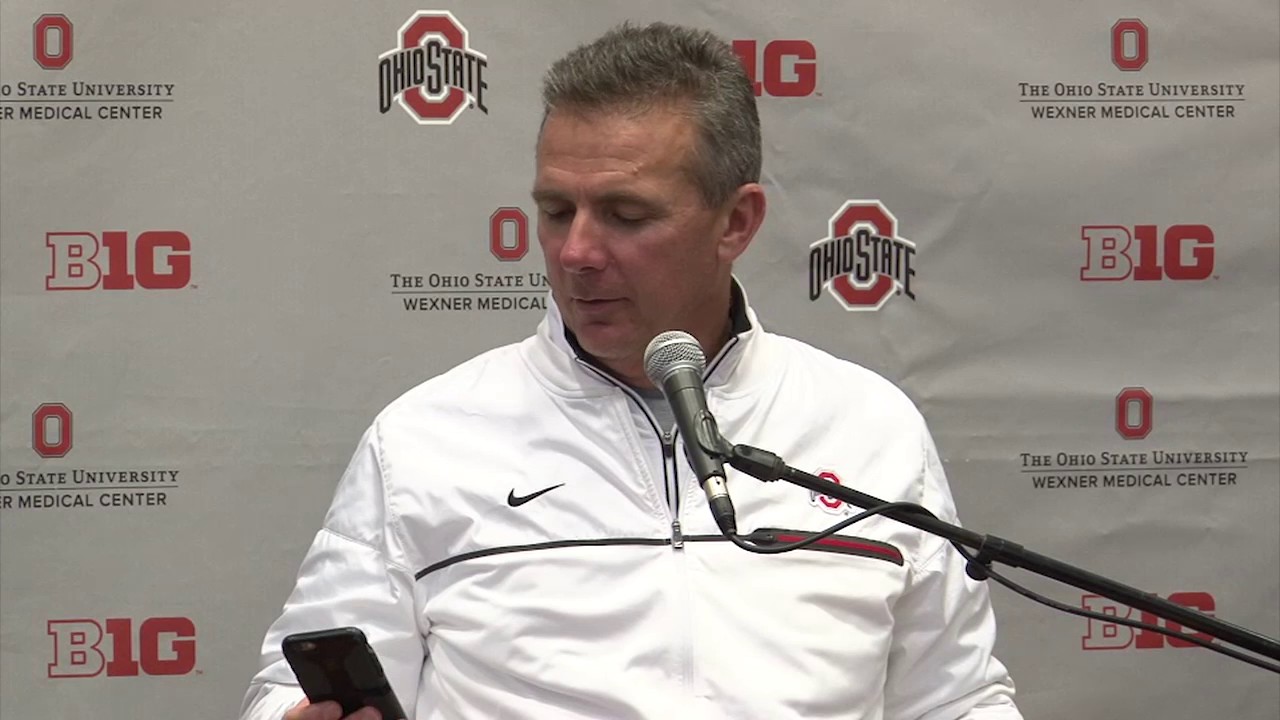Urban Meyer takes a phone call from his wife during Ohio State's press conference
